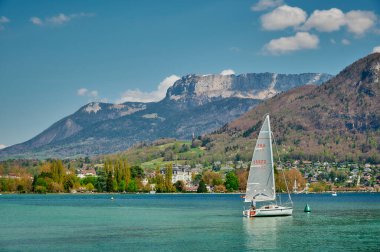Haute-Savoie, Fransa - 14 Nisan 2022: Turistler güneşli bir günde Annecy Gölü 'nde gemiye biniyorlar.