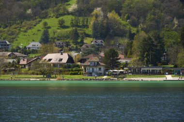 Güneşli bir günde Annecy Gölü çevresinde bir manzara. Annecy Gölü, Fransa 'nın Haute-Savoie kentinde bulunan bir perialpin gölüdür..