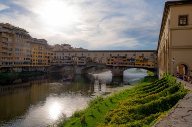 Tarihi Ponte Vecchio köprüsü ve İtalya 'nın Floransa kentindeki Arno Nehri' nin huzurlu manzarası. Sudaki canlı yansımalar resim gibi bir sahne yaratır..