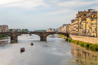 Tarihi Ponte Vecchio köprüsü ve Floransa, İtalya 'da küçük bir kayık geçidi olan Arno Nehri' nin huzurlu manzarası..