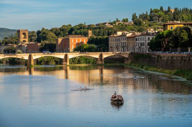 Floransa, İtalya - 8 Ağustos 2023: Tarihi Ponte Vecchio köprüsü ve İtalya 'nın Floransa kentinde küçük bir kayık geçidi bulunan Arno Nehri' nin huzurlu manzarası.