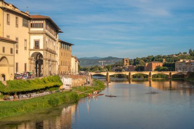 Tarihi Ponte Vecchio köprüsü ve Floransa, İtalya 'da küçük bir kayık geçidi olan Arno Nehri' nin huzurlu manzarası..