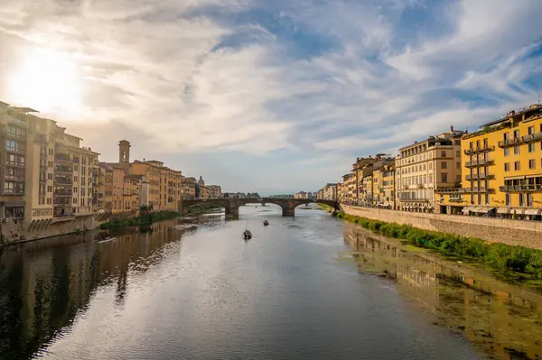 Tarihi Ponte Vecchio köprüsü ve Floransa, İtalya 'da küçük bir kayık geçidi olan Arno Nehri' nin huzurlu manzarası..