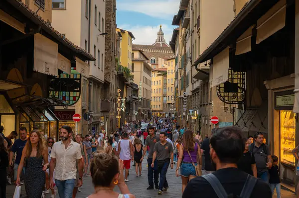 Floransa, İtalya - 8 Ağustos 2023: İtalya 'nın Floransa kentindeki antik Ponte Vecchio köprüsünde gezinen turistler, kentin zengin tarihi ve canlı atmosferine gömüldü.