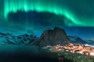 Kuzey ışıkları Hamnoy 'un üzerinde Lofoten Adası' nda dağlar ve denizlerle.