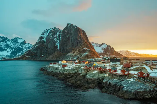 Lofoten Adası 'ndaki Hamnoy' un manzarası. Gün batımında arka planda karla kaplı dağlar..