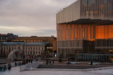 Oslo, Norveç - 13 Nisan 2024: Oslo Opera Evi 'nin çevresindeki insanların yürüyüp dinlendiği bir manzarası. Sahne alacakaranlıkta çekilmiştir..