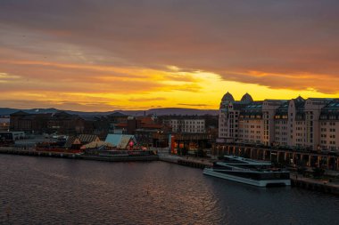 Oslo, Norveç - 13 Nisan 2024: Oslo limanının çevresi insanların yürüdüğü ve dinlendiği bir manzarası. Sahne alacakaranlıkta çekilmiştir..