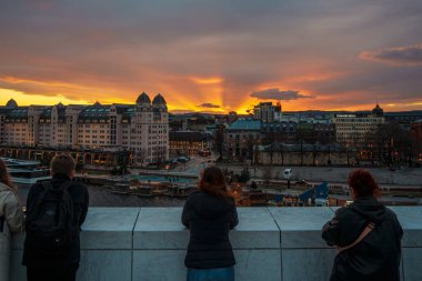 Oslo, Norveç - 13 Nisan 2024: Oslo Opera Evi 'nin çevresindeki insanların yürüyüp dinlendiği bir manzarası. Sahne alacakaranlıkta çekilmiştir..
