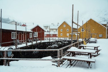 Kış manzarasında fiyortlu, karla kaplı renkli bir köy. Nusfjord, Lofoten.