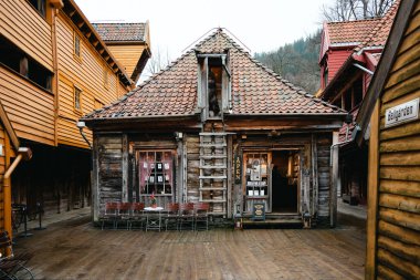 Bergen, Norveç - 12 Nisan 2024: Bryggen, Bergen 'de geleneksel kereste binaları ve dar tarihi geçitlerle çevrili kırsal bir ahşap dükkanın gündüz görünümü.