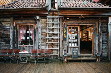 Bergen, Norveç - 12 Nisan 2024: Bryggen, Bergen 'de geleneksel kereste binaları ve dar tarihi geçitlerle çevrili kırsal bir ahşap dükkanın gündüz görünümü.