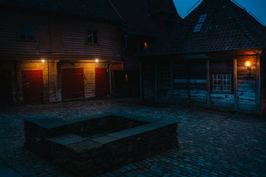 Norveç, Bergen 'deki Bryggen İskelesi' nden atmosferik gece sahneleri, rahat dükkanları, aydınlık sokakları ve sıcak ışıklandırmadaki ahşap tarihi binaları gösteriyor..