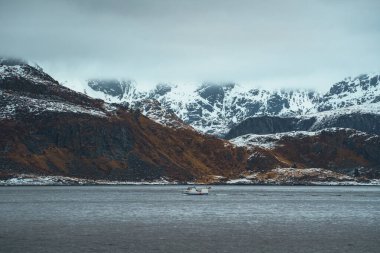Kışın şafak vakti Lofoten 'daki bir dağ sırasının dramatik karlı manzarası. Norveç.