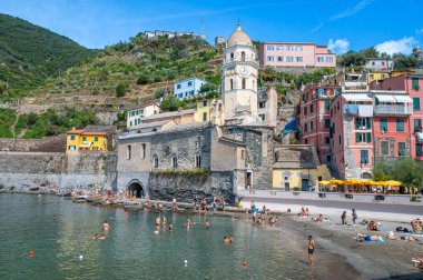 Vernazza, İtalya - Sep 7, 2022: Cinque Terre, İtalya 'daki Vernazza sahili, canlı binalar, sahile gidenler, tekneler ve Akdeniz cazibesine sahip.