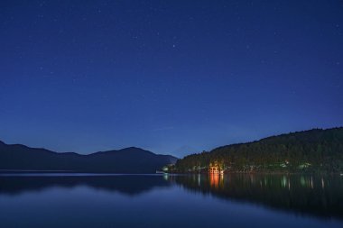 Geceleri Hakone Tapınağı 'nın kırmızı Torii kapısının manzarası. Torii kapısındaki Japonca metin 