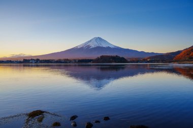 Fuji Dağı 'nın güneş doğarken Kawaguchiko Gölü' nün sakin sularındaki mükemmel yansıması..