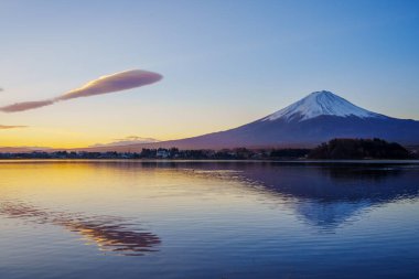 Merceksi bulutlarla dolu dramatik günbatımı gökyüzü Fuji Dağı eşliğinde Kawaguchiko Gölü 'ne yansıyor..