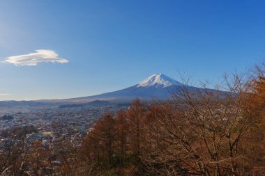 Fuji Dağı 'nın engin Fujiyoshida şehir manzarasının üzerindeki ufka hakim olduğu nefes kesen geniş bir görüntü..