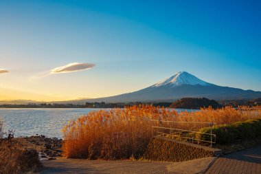 İkonik Fuji Dağı, sonbaharda Kawaguchiko Gölü üzerinde görkemli bir şekilde yükselir..