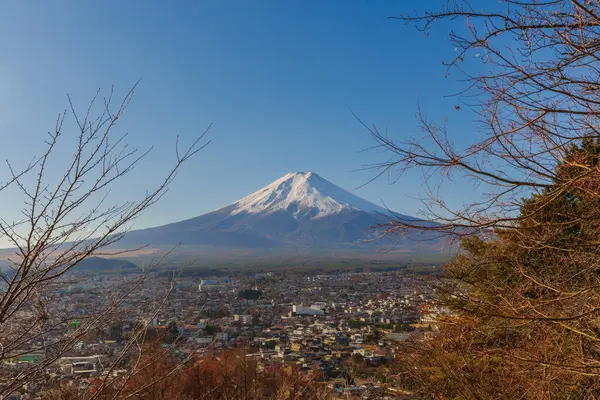 Fuji Dağı 'nın engin Fujiyoshida şehir manzarasının üzerindeki ufka hakim olduğu nefes kesen geniş bir görüntü..