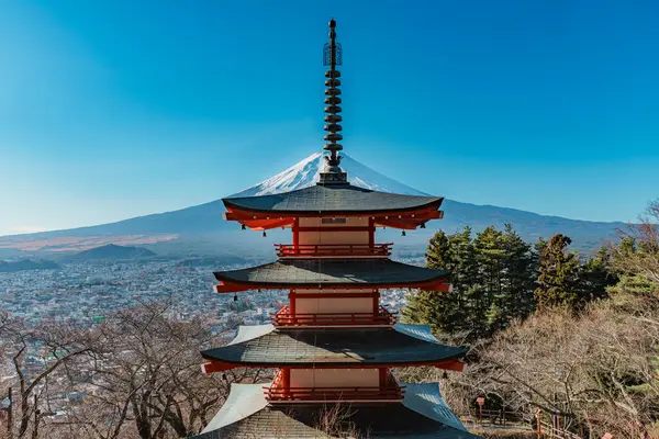 İkonik Chureito Pagoda ile Fuji Dağı ve Fujiyoshida şehri mavi gökyüzünün altında panoramik bir manzara.