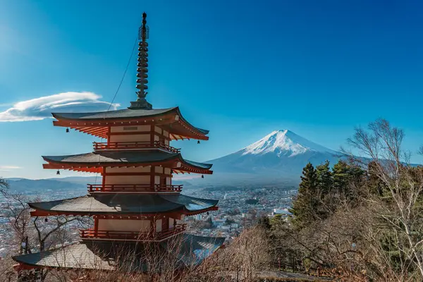 İkonik Chureito Pagoda ile Fuji Dağı ve Fujiyoshida şehri mavi gökyüzünün altında panoramik bir manzara.