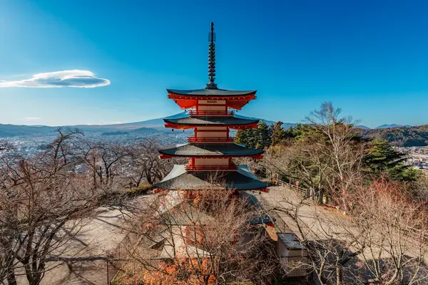 İkonik Chureito Pagoda ile Fuji Dağı ve Fujiyoshida şehri mavi gökyüzünün altında panoramik bir manzara.