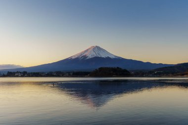 Fuji Dağı 'nın güneş doğarken Kawaguchiko Gölü' nün sakin sularındaki mükemmel yansıması..
