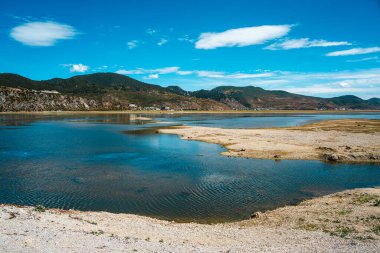 Çin 'in Şangri-la kentindeki Napahai Gölü' nün sakin manzarasında mavi su, kumsallar ve mavi gökyüzü var..