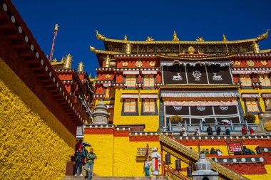 Songzanlin Manastırı 'nın görkemli sarı ve beyaz binaları Şangri-la, Çin' de canlı bir mavi gökyüzüne karşı duruyor..