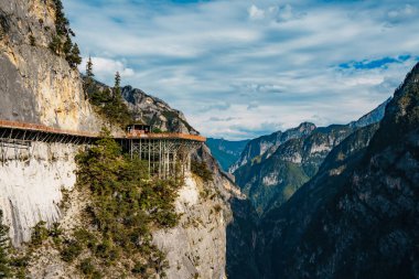 Balagezong Sahne Bölgesi, Shangri-la, Çin 'de kayalıklar boyunca uzanan ahşap bir patika.