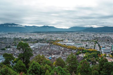 Çin 'in Yunnan kentindeki Lijiang şehrinin panoramik manzarasında, arka planda Yeşim Ejder Karlı Dağı var..