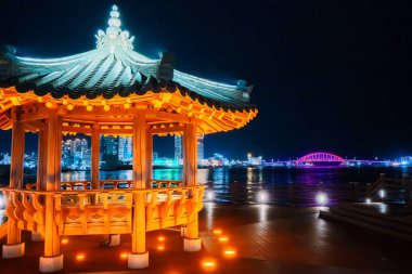 Geleneksel göl manzarası geceleri modern Sokcho silueti ve Güney Kore 'nin Cheongchoho Gölü' nde su yansımaları ile parlıyor..