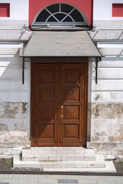 Güneşli bir günde eski duvarları olan eski bir taş binanın ahşap giriş kapısı. Eski şehrin mimarisi, hiç kimse..