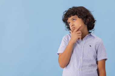 İfade eden bir çocuk gökyüzüne bakıyor ve düşünüyor.