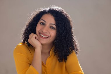 Gri arkaplan ile gülümseyen kadın portresi