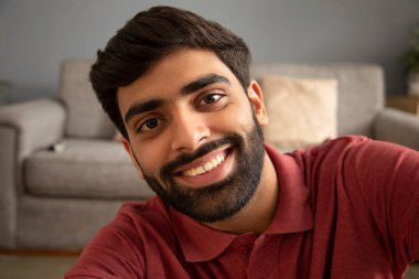 Sakallı yakışıklı genç adamın yakın plan portresi.