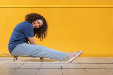 Mutlu kadın oturma odasında kaykay yaparken eğleniyor.