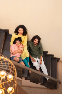 Evde merdivenlerde oturan aile üyelerinin genel görünüşü