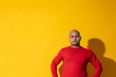 Sade arka planda ciddi ifadeleri olan kel bir adamın portresi..