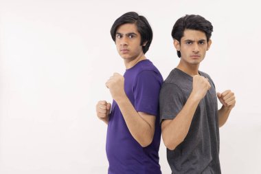 Arka arkaya yumruklarını kaldırmış iki gencin portresi.