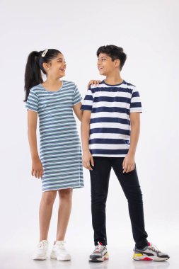 Beyaz arka planda duran iki neşeli çocuğun portresi