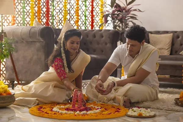 Güney Hintli çift Onam 'ı kutlamak için çiçek çelengi ile evi dekore ediyorlar.