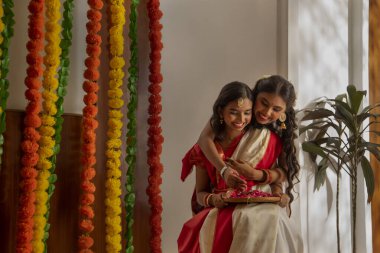 Durga Puja vesilesiyle geleneksel kıyafet dekorasyon evinde iki Bengalli kız kardeşin portresi.