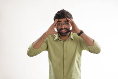 Beyaz arka plana el sallayan gülümseyen bir gencin portresi.