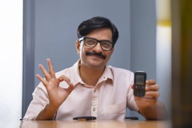 Kan şekeri seviyesi Glukometre 'de normalken adam rahatlıyor.