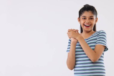 Beyaz arka planda hareketler yapan neşeli bir kızın portresi