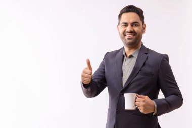 Neşeli genç bir iş adamının portresi. Kameraya bakıyor ve başparmağını kaldırıyor.