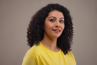 Kameraya bakan gülümseyen genç bir kadının yan görüntüsü